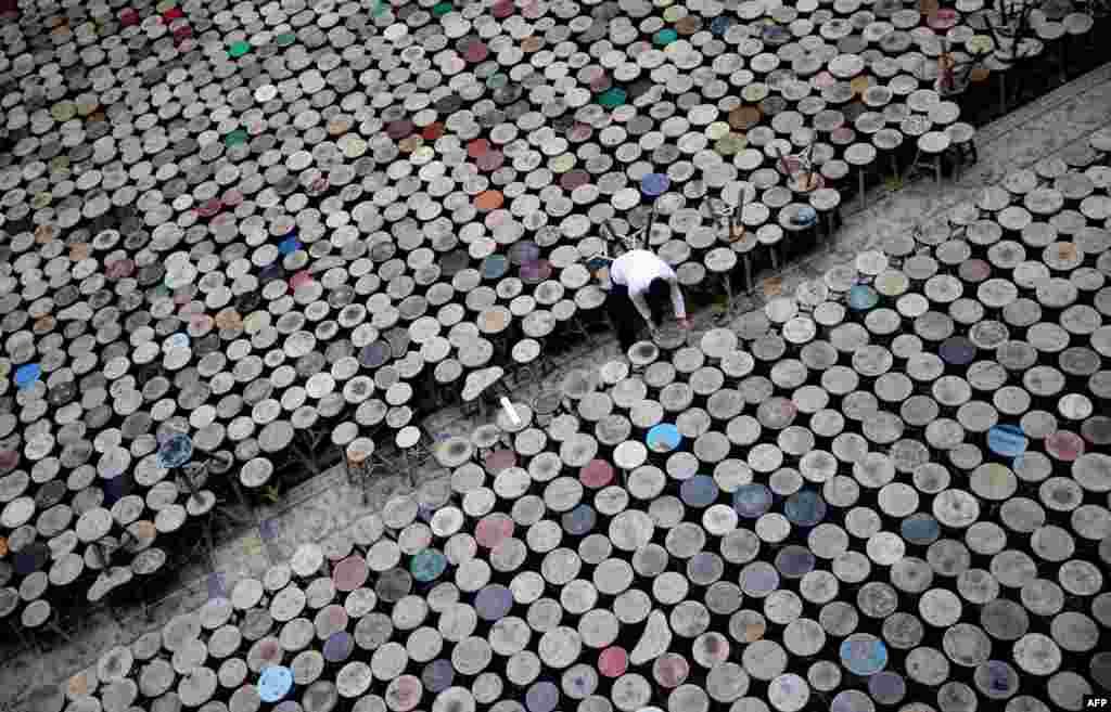 Seorang staff membantu mengatur instalasi "kursi" dari seniman China Ai Weiwei yang terbuat dari 6000 kursi tanpa lengan di ruang pameran atrium Martin-Gropius-Bau di Berlin, Jerman.