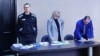 Ruski opozicioni lider Aleksej Navalni prisustvuje sudskom pretresu putem video linka, sa advokatima Olgom Mihailovom i Vadimom Kobzevom (Foto: REUTERS/Evgenia Novozhenina)