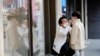A man and a boy wear masks to prevent contracting a new coronavirus at Myeongdong shopping district in Seoul, South Korea, Feb. 20, 2020. 