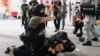 A police officer raises his pepper spray handgun as he detains a man during a march against the national security law at the anniversary of Hong Kong's handover to China from Britain in Hong Kong, July 1, 2020.