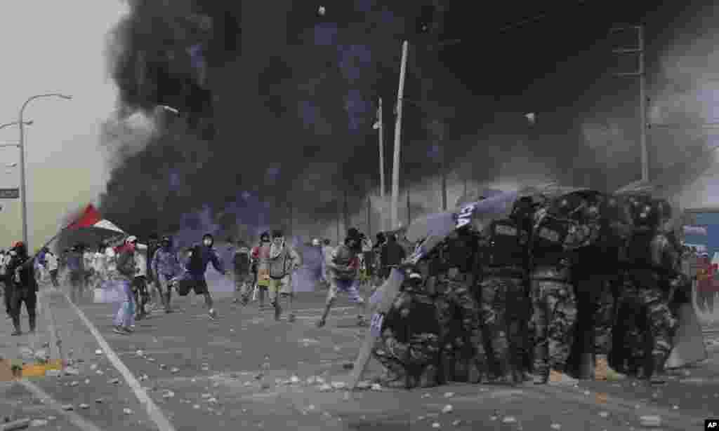 Farmworkers throw rocks at police on the Pan-American South Highway as they protest the Agricultural Promotion Law in the Barrio Chino neighborhood of Peru's Ica province, Dec. 22, 2020.