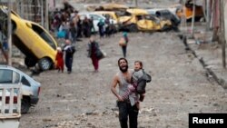Čovek hoda iz dela Mosula pod kontrolom ID ka vojnicima iračkih specijalnih snaga tokom bitke za Mosul