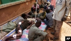 FILE - Wounded Malian troops receive medical treatment after being injured by a suicide bomber in an explosives-laden vehicle at the Joint Operational Mechanism base in Gao, Mali, Jan. 18, 2017.