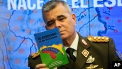 El ministro de defensa de Venezuela, general en jefe Vladimir Padrino López, lee un folleto sobre la soberanía de su nación en el Esequibo, durante una conferencia de prensa de voceros del gobierno de Nicolás Maduro en Caracas, en octubre de 2023.