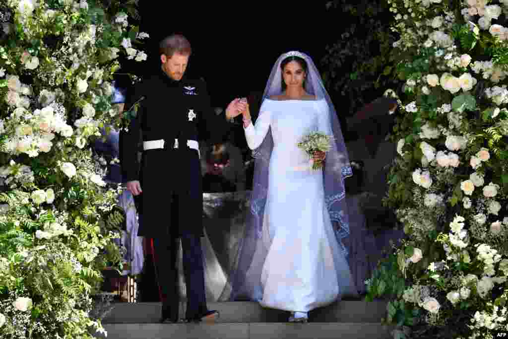 Britain's Prince Harry, Duke of Sussex and his wife Meghan, Duchess of Sussex walk down the west steps of St George's Chapel, Windsor Castle, in Windsor, May 19, 2018 after their wedding ceremony.