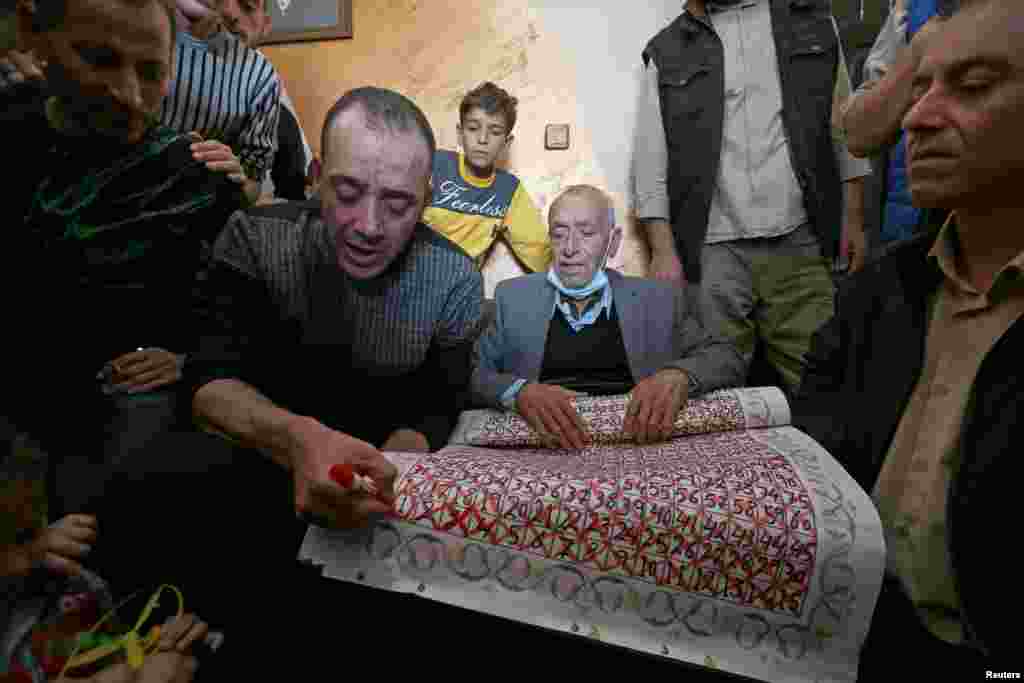 Freed Palestinian prisoner Abdel-Raouf Qe'dan, who served a 16-year sentence in an Israeli jail, marks the last day on a calendar made by his father, who was counting down the days until his son's release, in Rafah in the southern Gaza Strip.