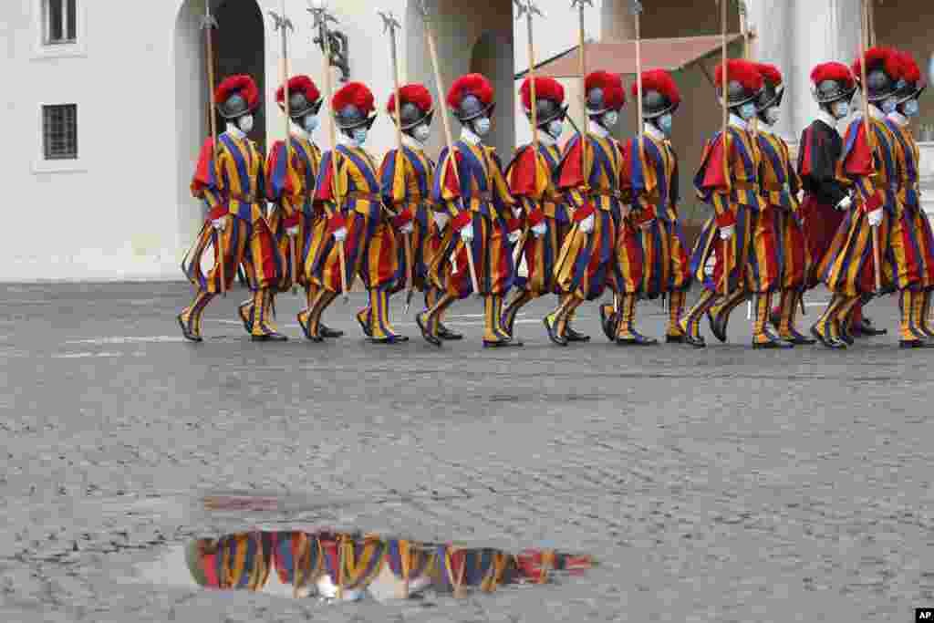 Vatican Swiss Guards wearing masks leave the St. Damaso courtyard after the visit of Spain's Prime Minister Pedro Sanchez to Pope Francis, at the Vatican, Oct. 24, 2020. 