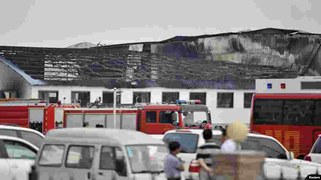 Rescue workers and fire trucks are seen outside a site of a fire, at a poultry slaughterhouse in Dehui, Jilin province, June 3, 2013.