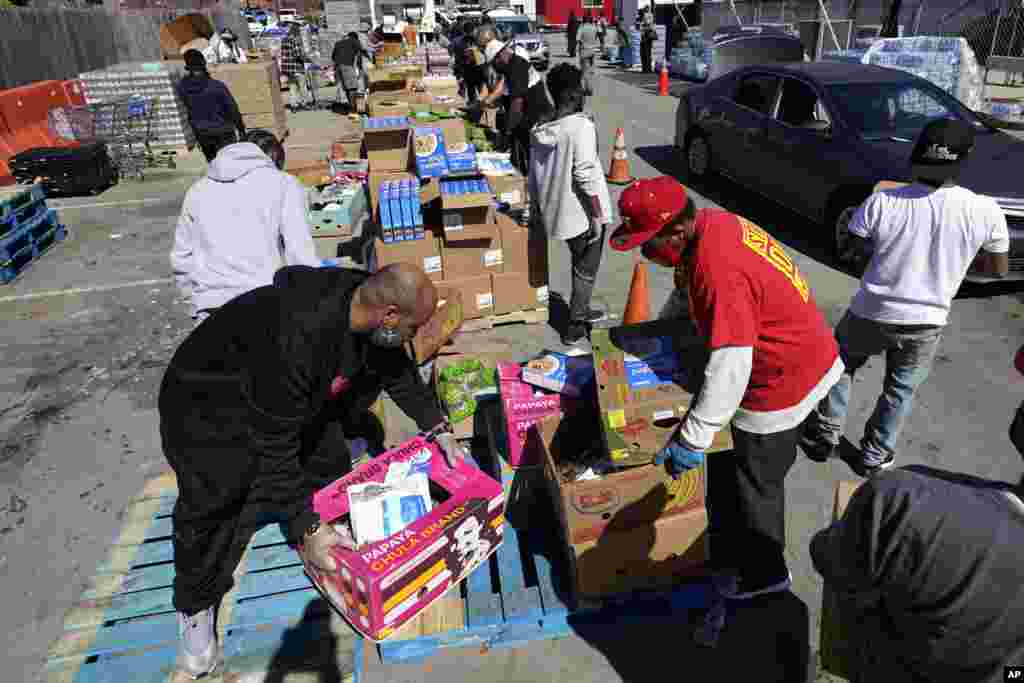 Volunteers load vehicles with food and water at a distribution site in Houston, Texas. The city's boil water notice has been rescinded, however, many residents lack water at home due to broken pipes. 