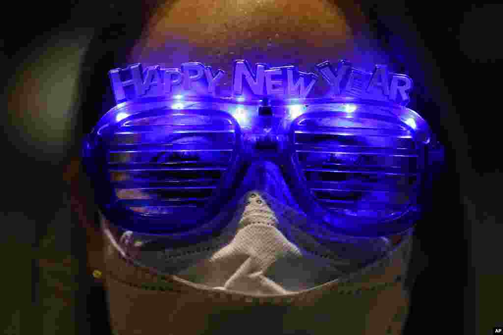 Alejandra Paiz, a tourist from Guatemala who is visiting Mexico for the holidays, wears festive glasses to mark New Year's Eve at the Angel of Independence monument in Mexico City.