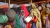 FILE - Women who fled drought queue to receive food distributed by local volunteers at a camp for displaced persons in the Daynile neighborhood on the outskirts of the capital Mogadishu, in Somalia, May 18, 2019.