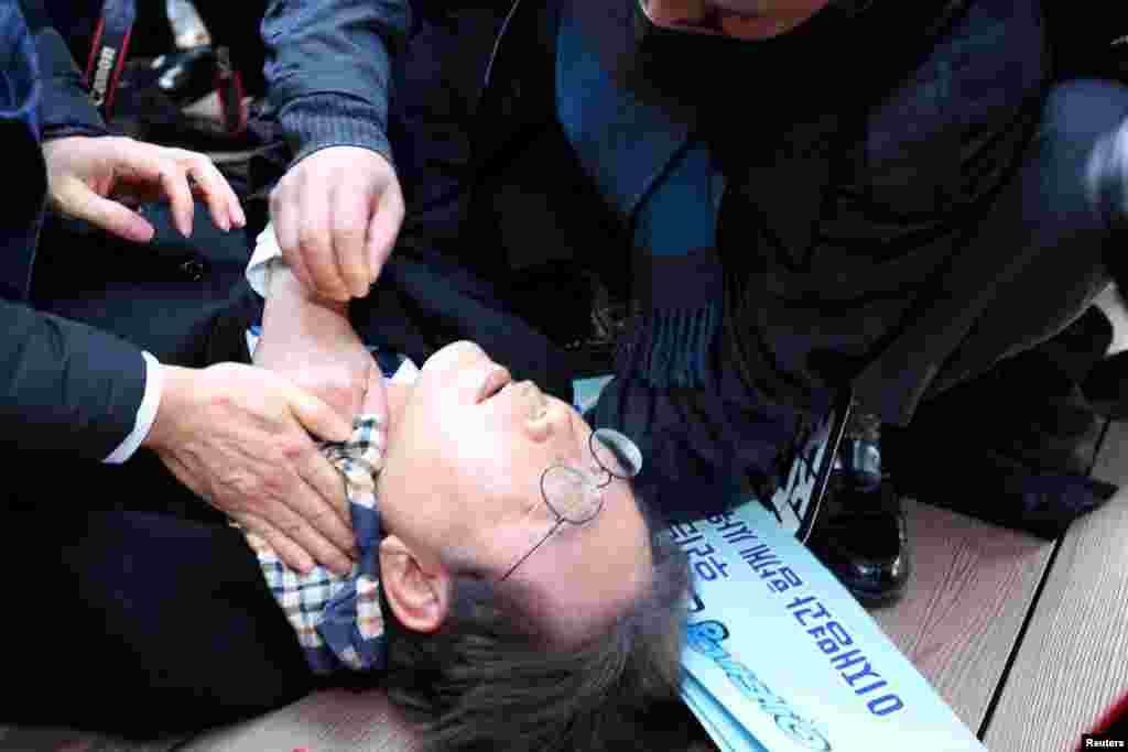South Korea's opposition party leader Lee Jae-myung falls after being attacked by an unidentified man during his visit to Busan.