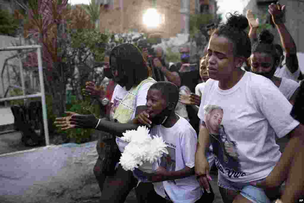 Relatives of Emily Victoria Silva dos Santos, 4, and Rebeca Beatriz Rodrigues dos Santos, 7, mourn during their burial at a cemetery in Duque de Caxias, Rio de Janeiro state, Brazil, Dec. 5, 2020. Emily and Rebeca were killed Friday night by bullets while playing outside their homes. 