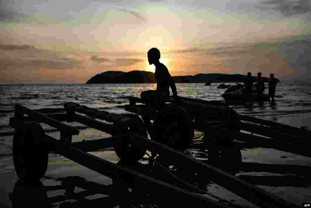 A boy sits on trailers during sunset at Cenang beach in Malaysia's popular island of Langkawi.