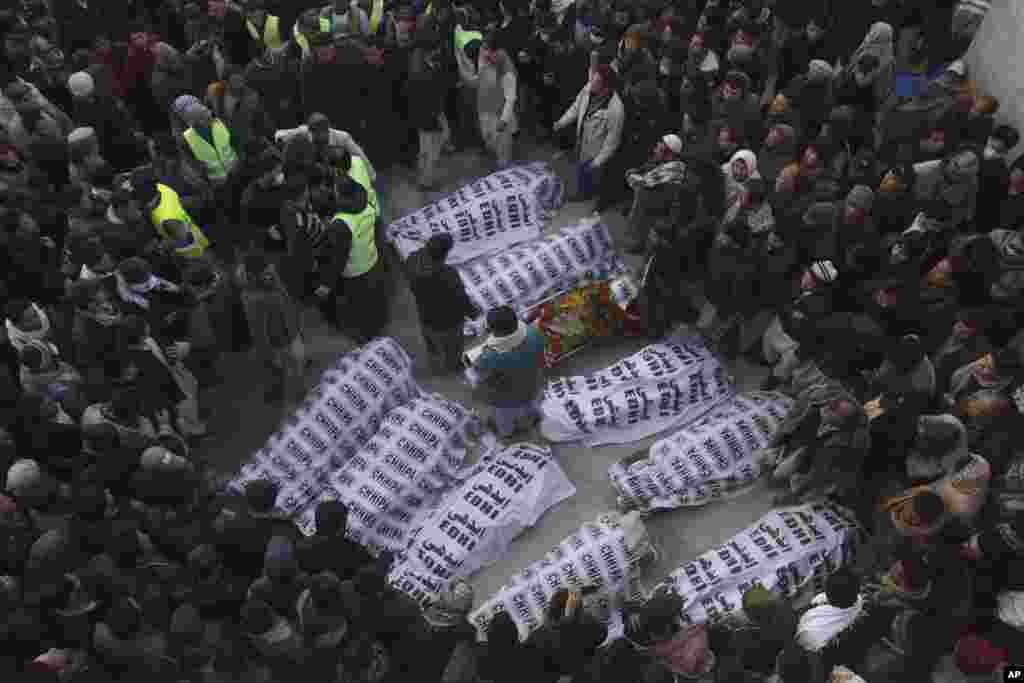 People from the Shi'ite Hazara community gather around the bodies of coal mine workers who were killed by unknown gunmen near the Machh coal field, in Quetta, Pakistan.