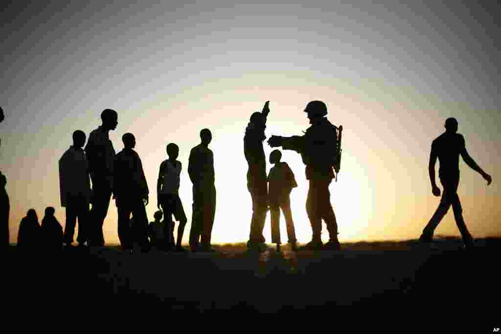 A French soldier checks passengers of a transport truck arriving in Gao, northern Mali, Feb. 14, 2013. Malian forces have stepped up security around the port and the main market, in an effort to stop the infiltration of rebel fighters in the town.