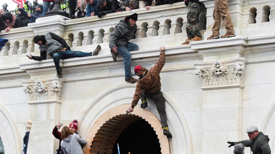 Pristalice predsednika Trampa penju se na balkon zgrade Kapitola, 6. januara 2021.