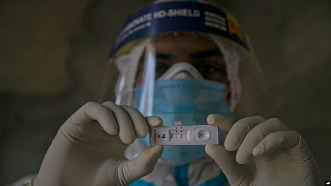 Arhiva - Zdravstveni radnik drži test na koronavirus.