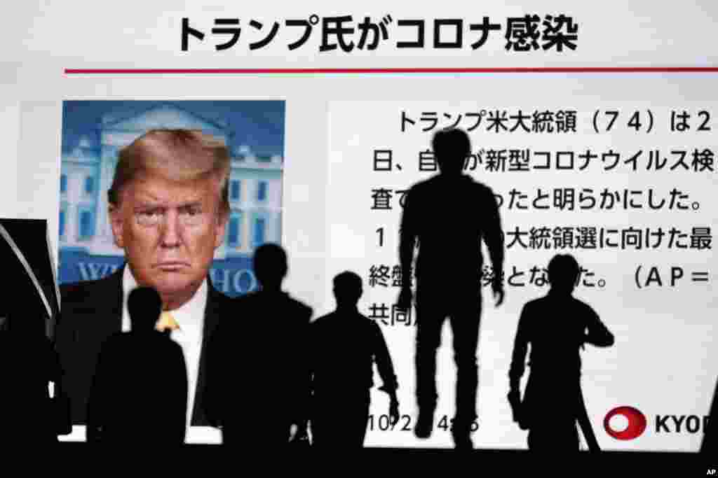 일본 도쿄 시민들이 대형 스크린에 나오는 도널드 트럼프 미국 대통령과 멜라니아 트럼프 여사의 코로나19 감염 소식을 보고있다.