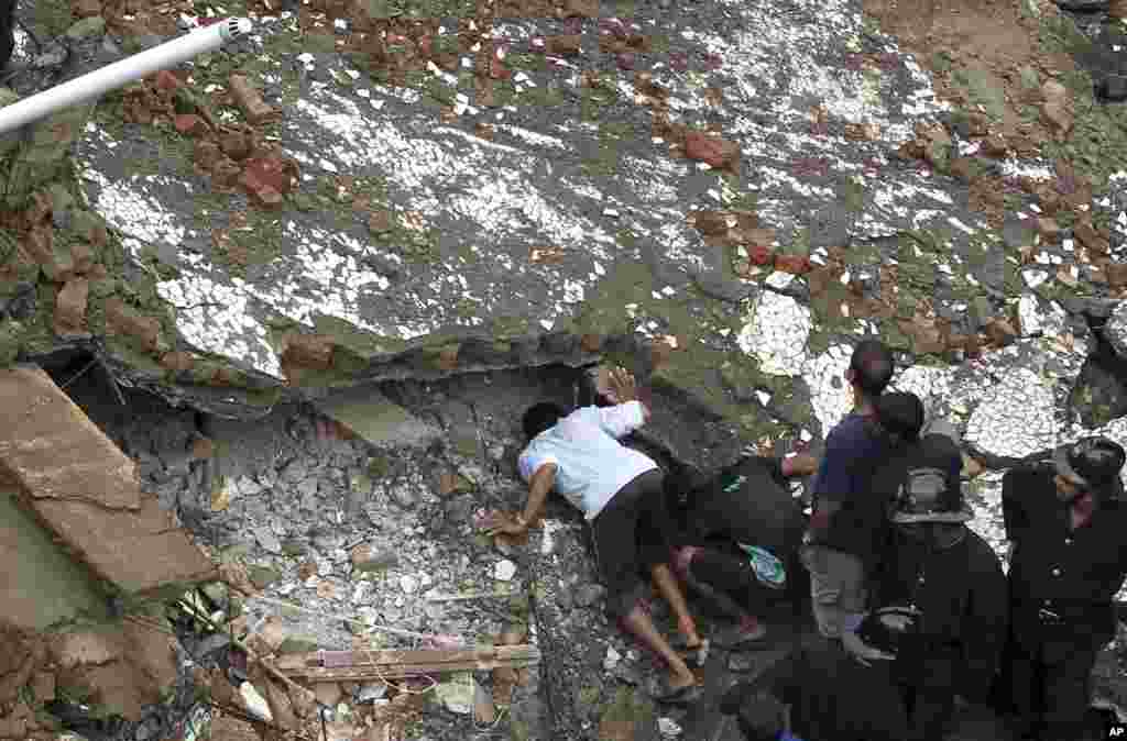Para petugas penyelamat mencari para penyintas di lokasi gedung apartemen yang ambruk di Mumbai (27/9).