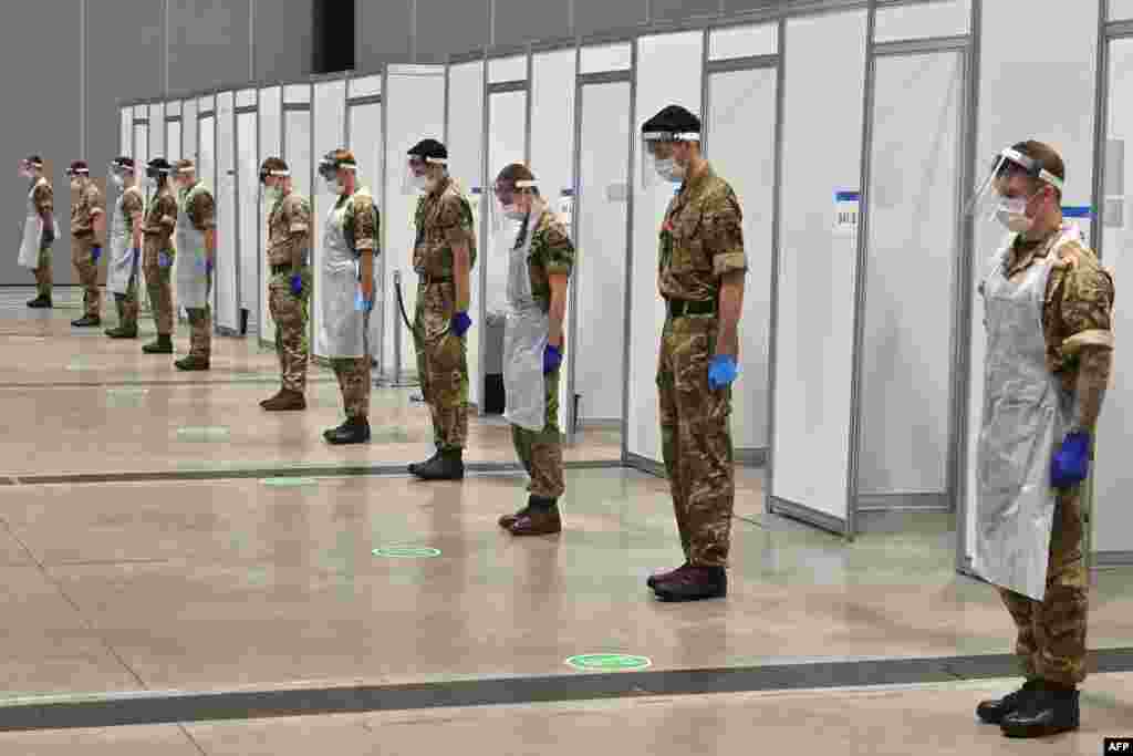Soldiers observe a 2-minute silence for Armistice day in remembrance of the nations war dead at a coronavirus rapid testing center in Liverpool, northwest England.