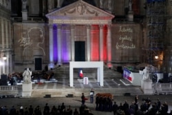 FILE - The coffin of slain teacher Samuel Paty is carried away in the courtyard of the Sorbonne university during a national memorial event, Oct. 21, 2020 in Paris.