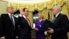 U.S. President Donald Trump, left, watches as Vice President Mike Pence, right, swears in Steve Mnuchin as Treasury Secretary next to his fiancé, Louise Linton, in the Oval Office of the White House in Washington, Feb. 13, 2017. 