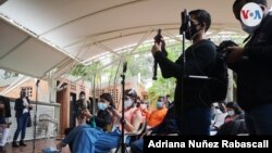 ARCHIVO - Periodistas venezolanos cubren una rueda de prensa de la oposición en Caracas, en abril de 2021.