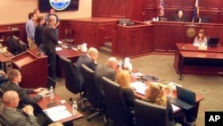 FILE - In this image taken from video, accused Colorado theater shooter James Holmes, standing on the far left, listens as the verdict is read during his trial, in Centennial, Colorado, July 16, 2015. 