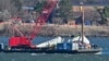 Спасательные команды ВМС США поднимают заднюю секцию крыла самолета American Airlines из вод Потомака в Арлингтоне, штат Вирджиния, 4 февраля 2025 года.