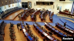 Empleados del Congreso organizan la sala tras la sesión especial de aprobación de la licencia del presidente Nayib Bukele, solicitada por el mandatario para ocuparse de la campaña de reelección de 2024, en San Salvador, el 30 de noviembre de 2023.