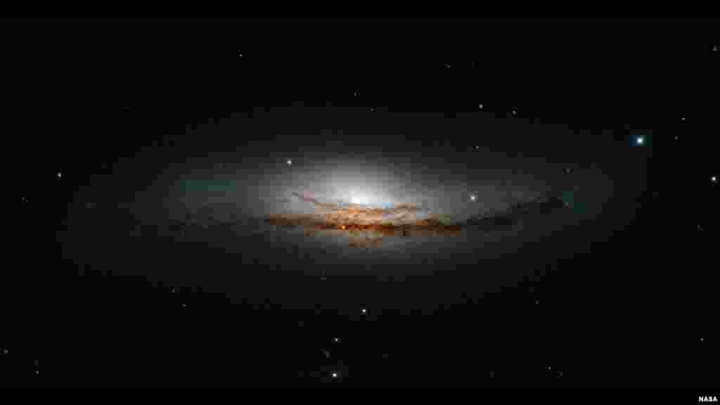 This new Hubble image is centered on NGC 5793, a spiral galaxy over 150 million light years away in the constellation of Libra. This galaxy has two particularly striking features: a beautiful dust lane and an intensely bright center — much brighter than that of our own galaxy, or indeed those of most spiral galaxies we observe. (Credit: NASA, ESA, and E. Perlman (Florida Institute of Technology))