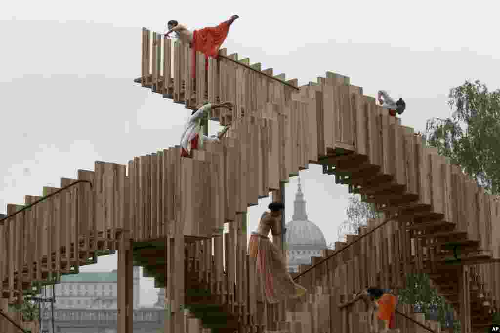 Para penari menari di atas "Tangga tak Berujung", tangga yang didirikan di luar galeri seni Tate Modern, dimana sebagian dari Katedral St. Paul terlihat di latar belakang, dalam sebuah acara untuk membuka Festival Disain London.