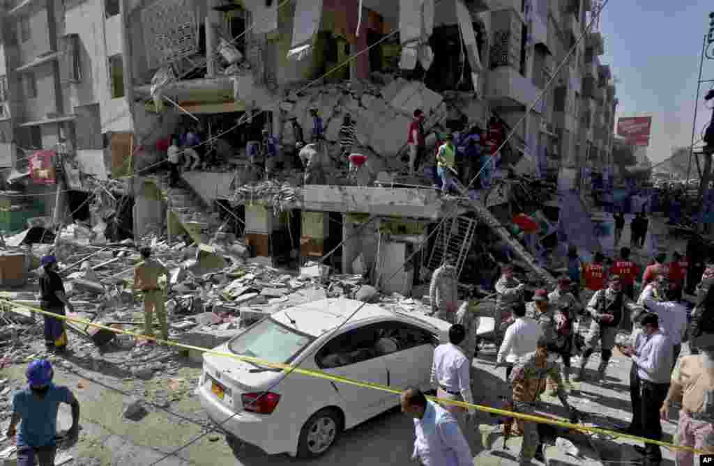 Pakistan's troops and rescue workers look for survivors in the rubble following the explosion, in Karachi.