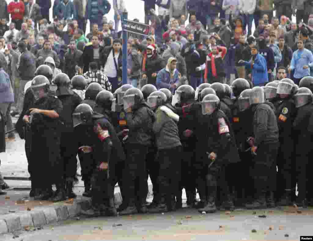 Riot policemen stand between protesters opposing Egyptian President Mohamed Morsi and others supporting him (not pictured) in Alexandria, Egypt, December 21, 2012.
