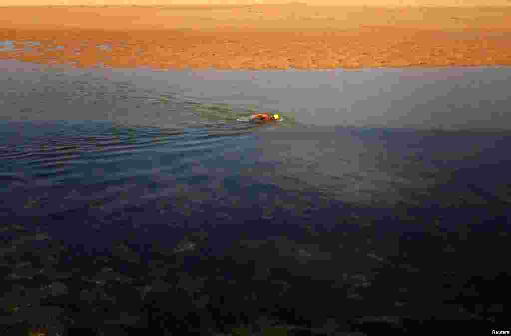 A man swims against the current at the entrance to Narrabeen Lake on a warm, spring day in Sydney, Australia.