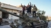 Para pejuang pro-Turki di Suriah berpose di atas sebuah tank di Maarat al-Numan, wilayah barat daya Aleppo, Suriah (30/11). 