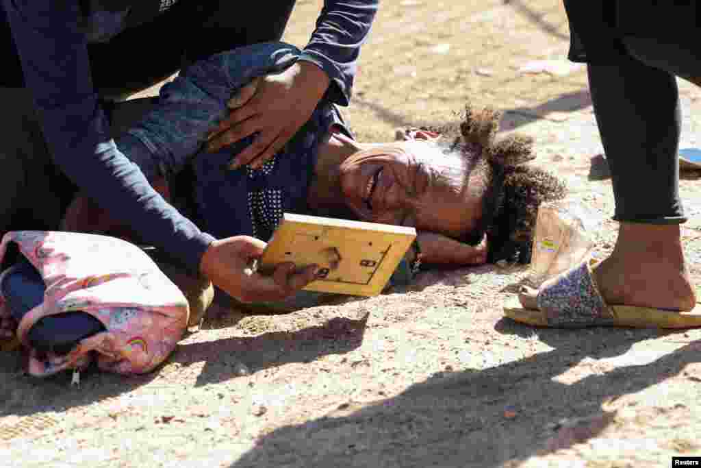 An occupant reacts after people are evicted from a piece of land, called "tent city," which they illegally occupied near the Green Point tennis courts in Cape Town, South Africa.