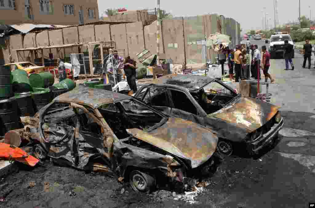 Cư dân Iraq tại hiện trường sau một vụ đánh bom xe ở Sadr City, Baghdad, ngày 23/7/2012