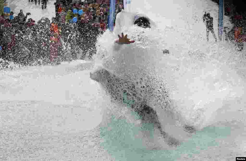 Seorang peselancar salju berusaha melompati kolam air sepanjang 26-meter di resor ski Bobrovy Log dekat kota Krasnoyarsk, Siberia, Rusia. 