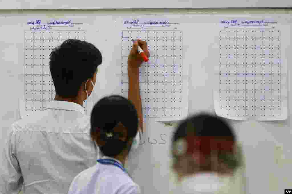 Election officials keep track of counted votes at a polling station after polls closed in Naypyidaw, Myanmar.