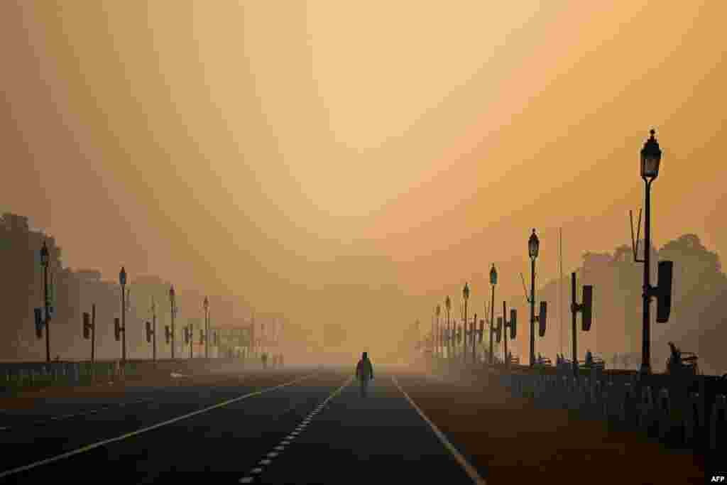 A man walks along Rajpath amid smoggy conditions in New Delhi, India.