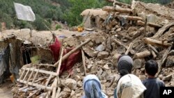 Anak-anak Afghanistan berdiri di dekat sebuah rumah yang hancur akibat gempa bumi di Distrik Spera di bagian barat daya Provinsi Khost, Afghanistan, Rabu, 22 Juni 2022. (Foto AP)