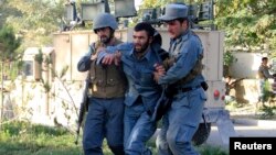 Cảnh sát Afghanistan giúp một đồng đội bị thương tại hiện trường sau vụ đánh bom tự sát ở tỉnh Ghazni, ngày 4/9/2014.