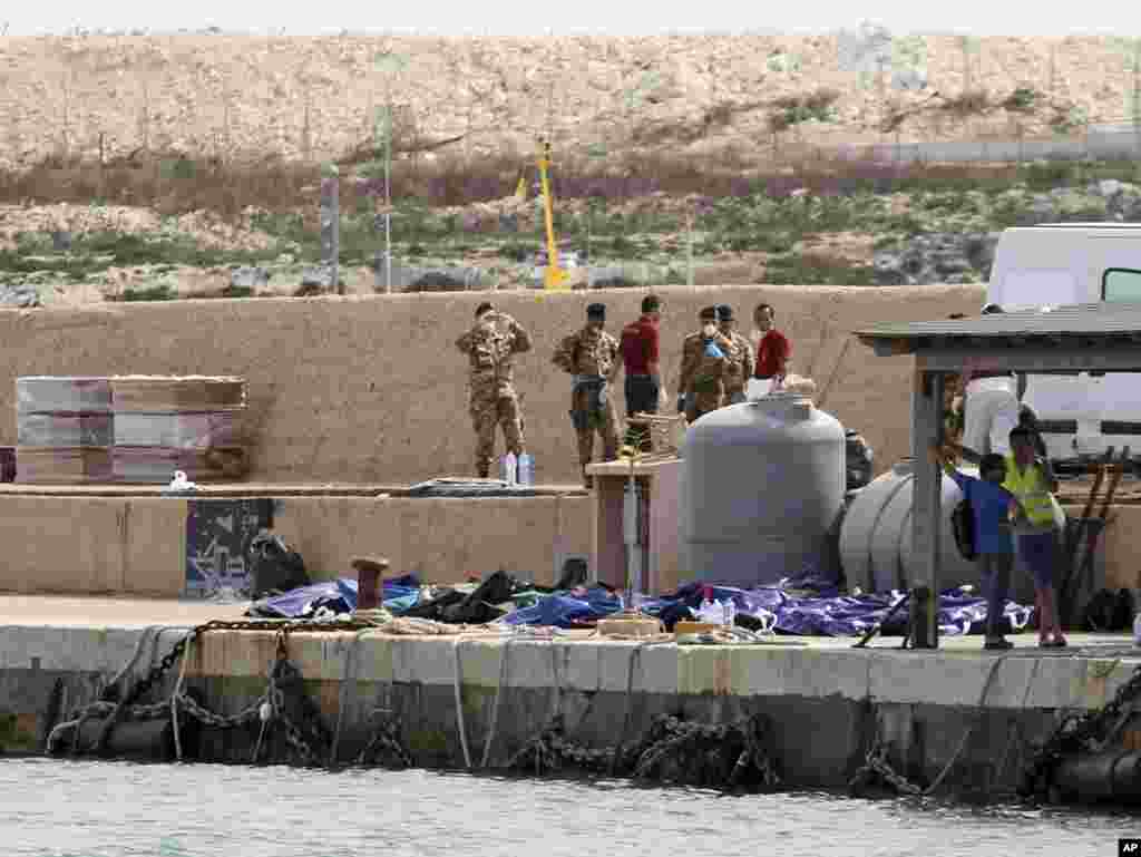 Jenazah para migran Afrika yang tenggelam di Laut Tengah tampak diletakkan berjejer di pelabuhan Lampedusa, sebuah pulau di lepas pantai Italia.