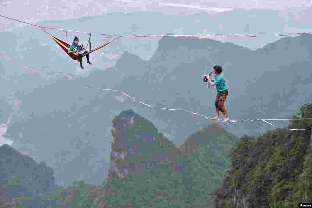 Members of performing group Houle Douce practise their instruments on tightropes ahead of a performance, at the Tianmen Mountain National Park in Zhangjiajie, Hunan province, China.