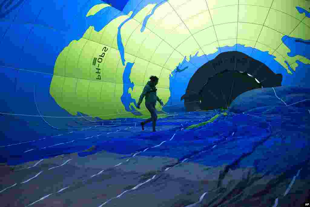 An environmental activist walks inside a hot air balloon before launching it during a demonstration outside of an EU summit in Brussels.