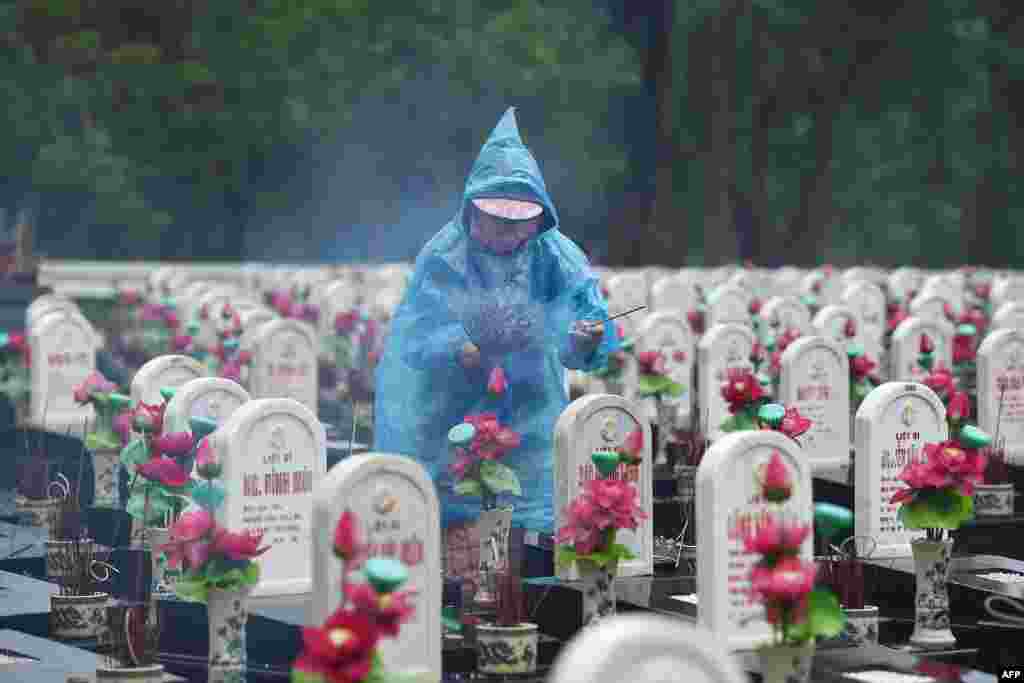 A visitor lights incense sticks at the Truong Son Martyr's Cemetery, where 10,263 Vietnamese war soldiers are laid to rest, in Quang Tri province, Vietnam.