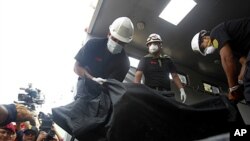 Cảnh sát khiêng thi thể một bệnh nhân ra khỏi trung tâm phục hồi bị hỏa hoạn ở ngoại ô Lima, ngày 5/5/2012
