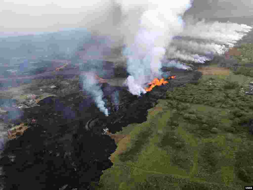 An aerial view shows erupting fissure and lava channels flowing southward from during an early morning eruptions of the Kilauea Volcano in Hawaii, May 21, 2018. (Photo courtesy of Volcano Helicopters)
